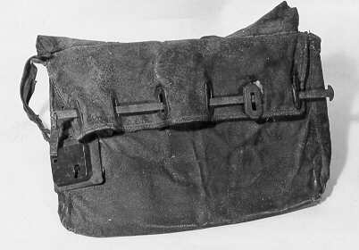 Postväska (lösväska) med trasig bärrem och låsinrättning.
Denna hade ursprungligen sex järnöglor (en kvar). Dessa träddes genom sex järnskodda hål på underklaffen. En järnten drogs igenom öglorna, och låstes med låset till vänster på väskan. Väskan är invändigt klädd med säckväv.