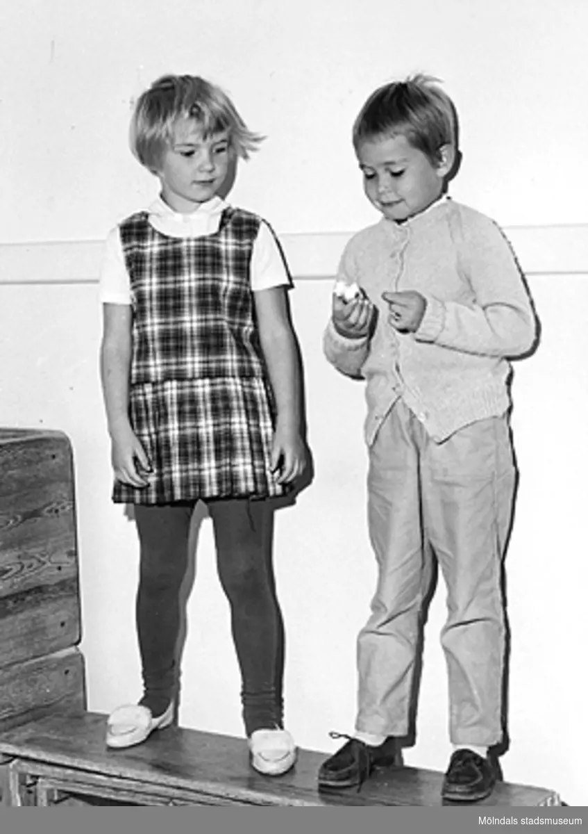 Två barn som står utefter en vägg inomhus. Holtermanska daghemmet 1953.