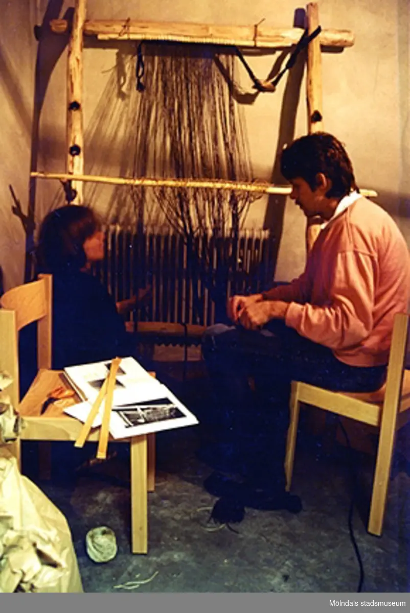 Uppsättning av upprättstående vävstol i järnåldershuset på museet. Gunilla Rajala från Alingsås museum samt okänd man.