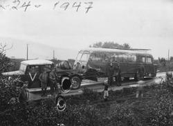 Bergingsbil med skadet buss. Personer i forgrunnen.