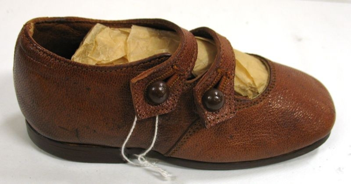 Barnsko med två knäppningar. Lädersula.

Demonstrationsexemplar av skor. Från  AB A F Carlssons skofabrik, Vänersborg.