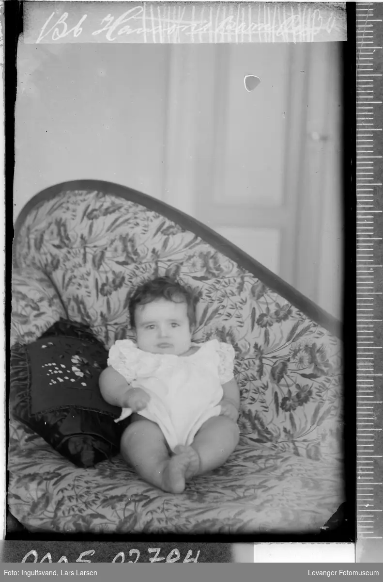 Portrett av et lite barn i en sofa.