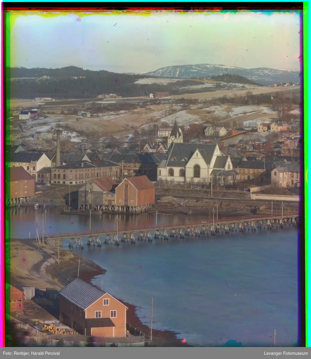 Oversiktbilde over Levanger sundet med Sundbroen midt i bildet. Bak ligger Levanger kirke og melkefabrikken. Bak kirketårnet ser man Brusve gård.