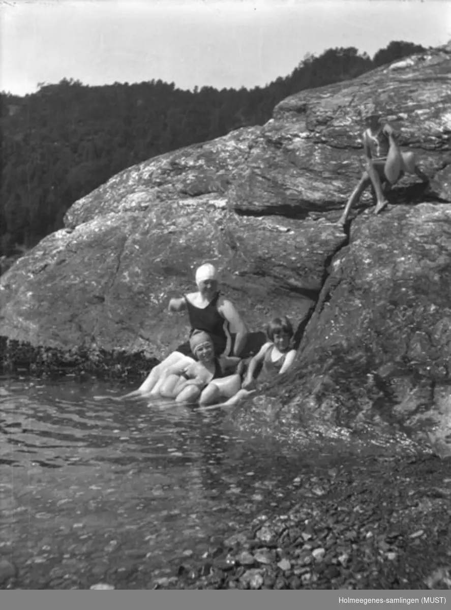 Fire jenter i badedrakt på/ved et svaberg. Fint vær med lette skyer på himmelen. Antatt samme sted og tidspunkt som ST.K.HE 2007-011-0054 og -0055.