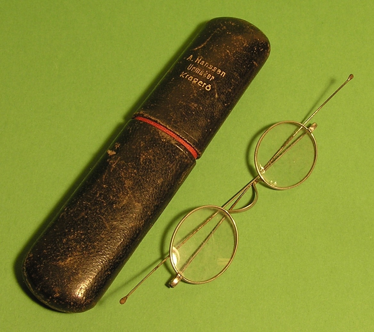 Oval tverrsnitt. Slank brillehus med briller. Briller har lange og  lett buet stenger.