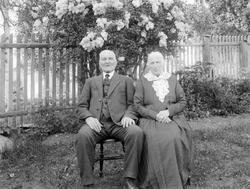 Herr og fru Olsen. Eldre par i hage.