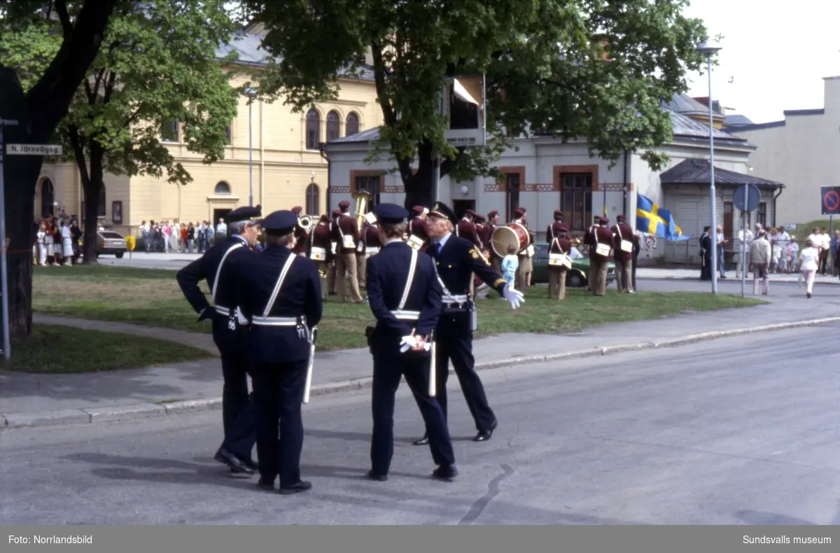 Kungligt besök i Sundsvall av kung Carl XVI Gustaf och drottning Silvia. Stort pådrag med körsång, folksamling, poliser och pressfotografer.