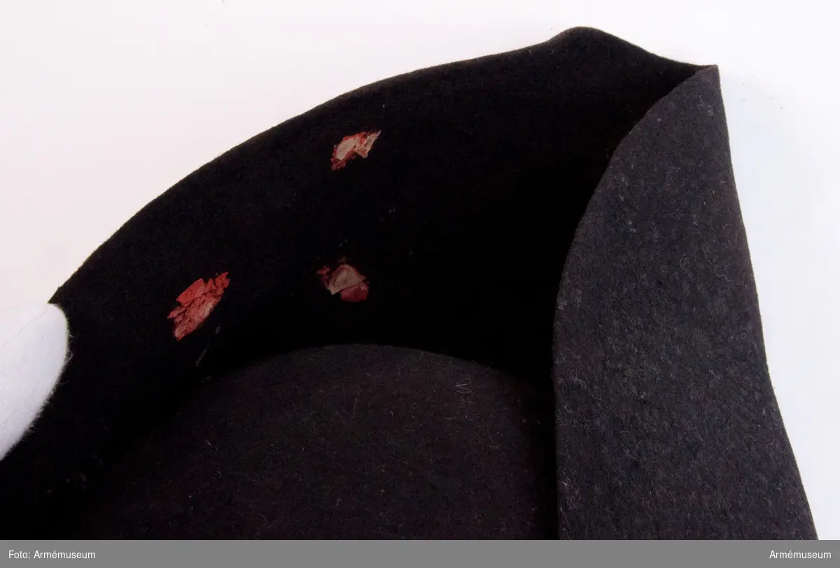 Grupp C I.
Trekantig svart hatt med mässingsknapp och rester av rött lacksigill.