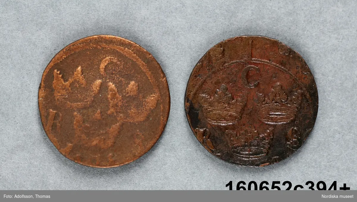 Två mynt med oläsliga årtal.