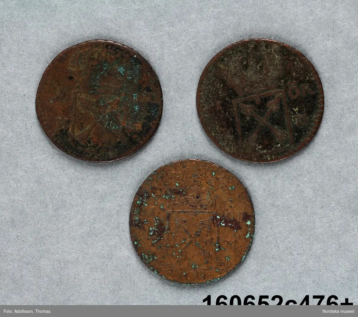 Tre mynt med oläsliga årtal.
