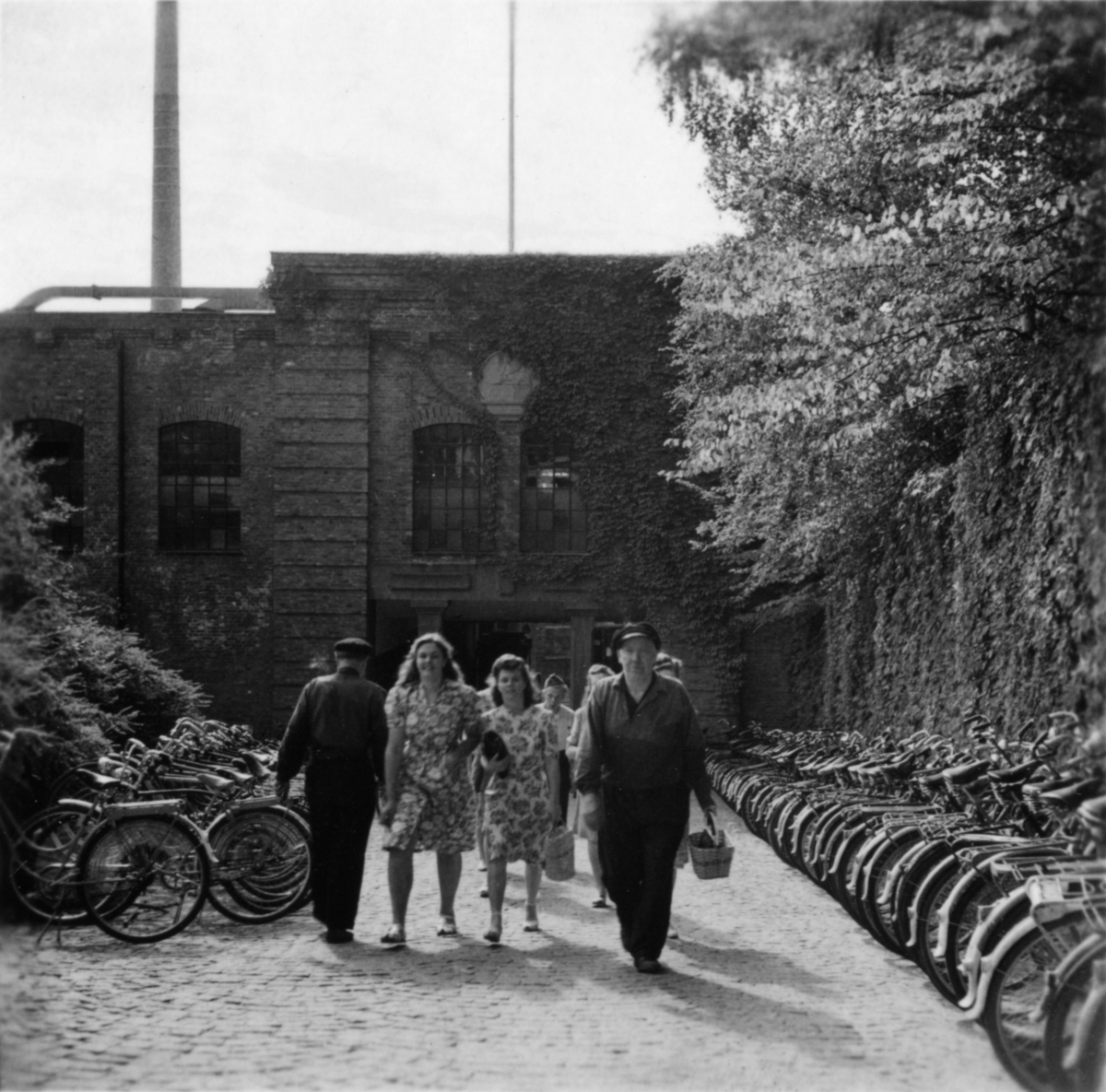 Porten vid Trädgårdsgatan, augusti 1947. Från vänster: Okänd, Gunhild Olsson, Signe Magnusson och smeden Sven Gustaf Svensson.