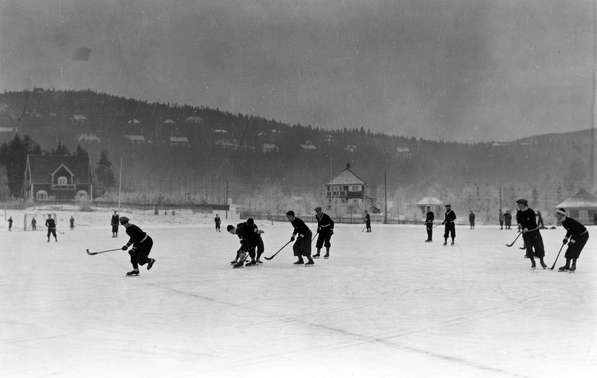 Skøyter. 1935. Bandy spilles på Gressbanen.
Holmenkollåsen i bakgrunnen.