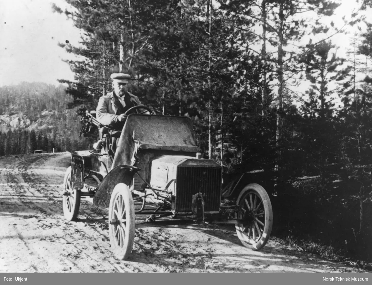 Distriktslege Torjus Lundevall i en Ford, Type N, R eller S. Disse typene var meget like og ble laget i årene 1905-1908. Ford T kom i produksjon i 1908. 
