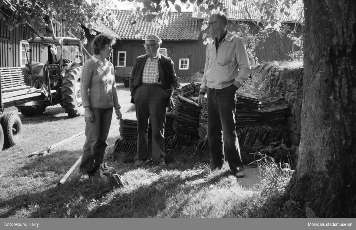 Hembygdsgården Börjesgården i Hällesåker, Lindome, år 1983. En kvinna och två män på gården.

För mer information om bilden se under tilläggsinformation.
