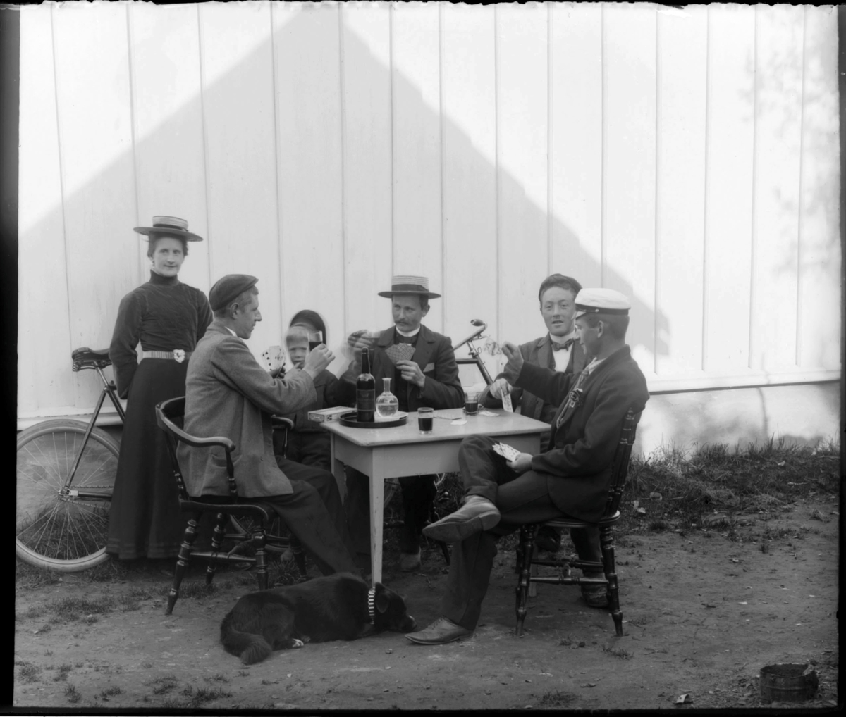 Fire menn spiller kort ute i solveggen