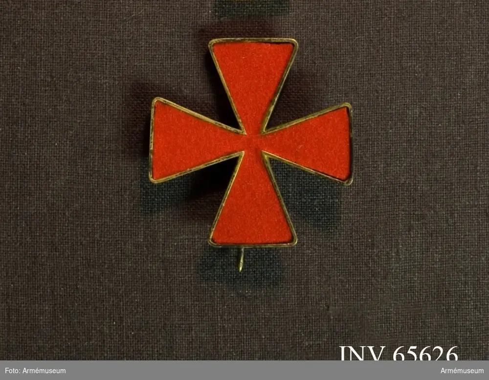 Grupp M II.
Karl XIIIs orden.
Ordenstecken i tyg att bäras på ordensdräkt. Ett St Georgekors av rött kläde, infattat i gyllene upphöjda kanter.