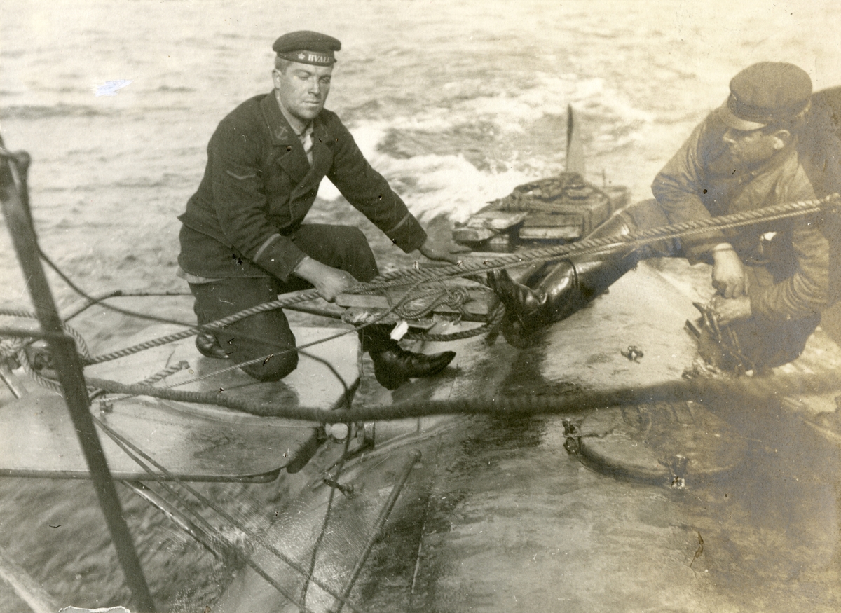 Två besättningsmän arbetar med nödriggning av trasigt roder ombord ubåten HVALEN utanför holländska kusten.