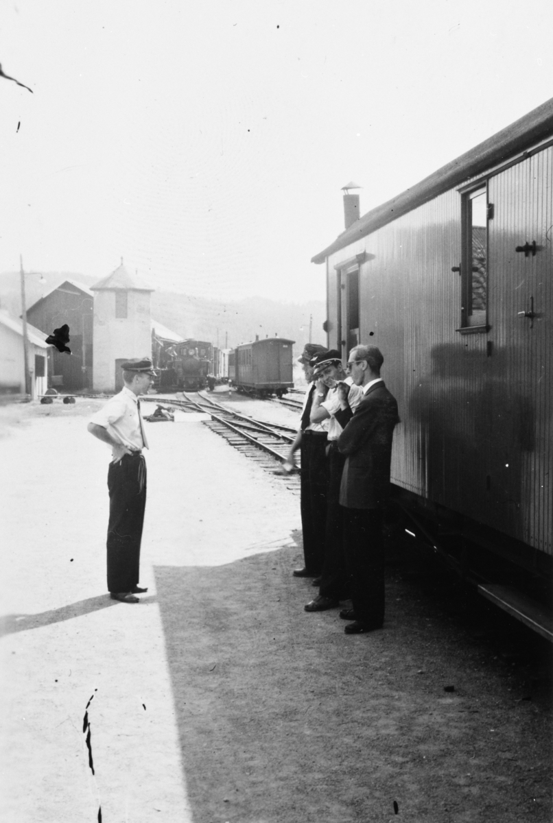 Stasjons- og togpersonale på plattformen under togets opphold på Bjørkelangen stasjon. Lokomotivet har gått rundt toget for å fylle vann fra søndre vanntårn.