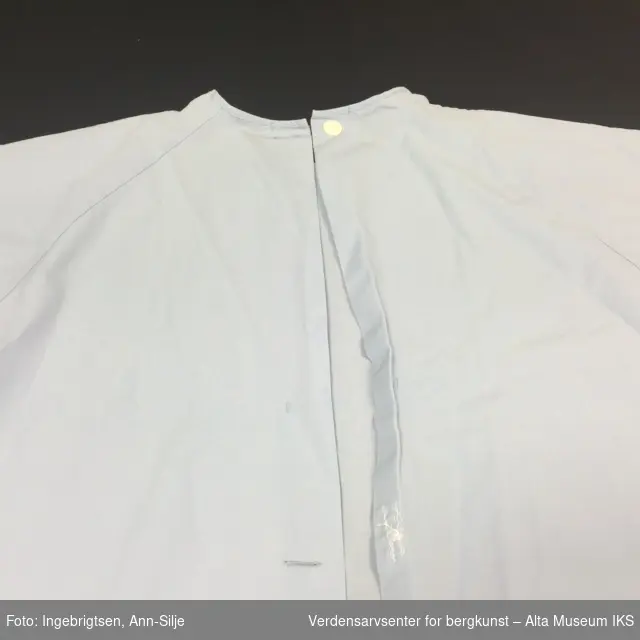 Blå kortermet nattskjorte/kjole med en hvit knapp i plast plassert i kragen.