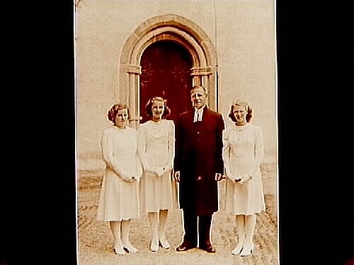 Privata konfirmander, 3 flickor och prosten G.B. Abrahamson.
Sköllersta kyrkas port och stiglucka i bakgrunden.