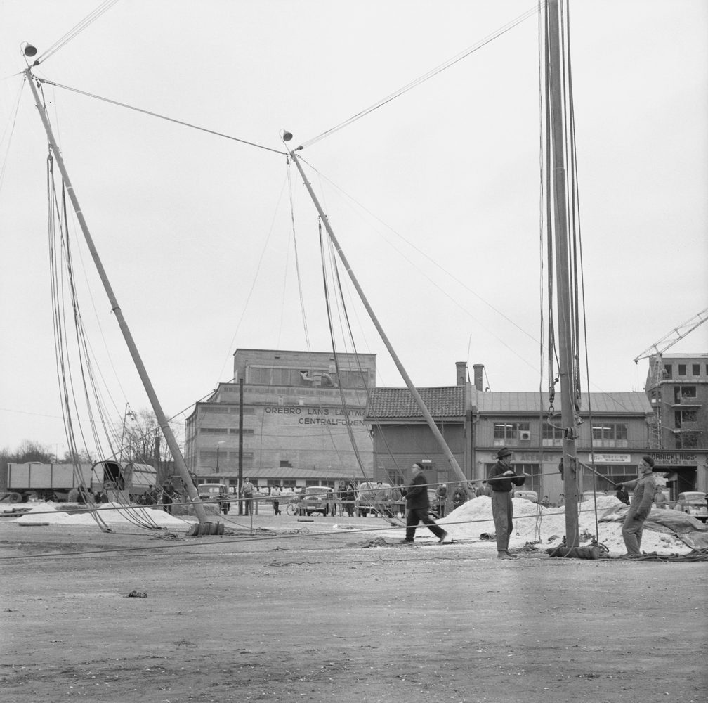 Cirkus i stan vid Hamnplan. Bildsidan.
 21 maj 1955.
I bakgrunden syns Centralföreningens silo. Till vänster från toppen på byggnaden ner mot Svartån går ett rör i 45 graders vinkel. Genom det röret transporterades silons säd ner till pråmarna i ån.