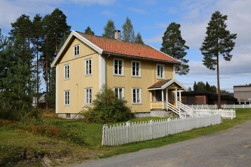 Stræte skole som står i museumsparken til Glomdalsmuseet. Det er en gul toetasjes bygning med et hvitt stakittgjerde.