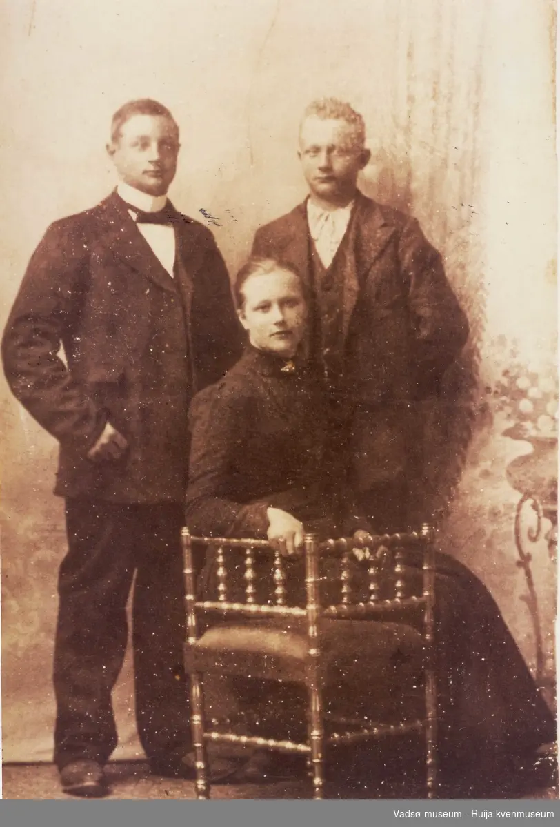 Kolanordmenn. 3 søsken hos fotograf. Bak fra venstre: Frederik Emanuel og Jacob Ingebrigt Knudsen. Foran Sitter Helga Sofie Knudsen. Ca 1910-1920