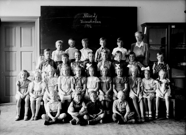 Vasaskolan, klassrumsinteriör, 27 skolbarn med lärarinna fröken Anna Dahlén.
Klass 2J, sal 8.