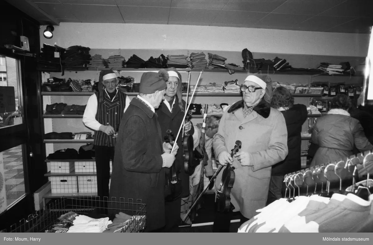 Underhållning i samband med Kållereds lucias kröning i Kållereds centrum, år 1983. Kållereds spelmanslag i en av butikerna i centrum.

För mer information om bilden se under tilläggsinformation.