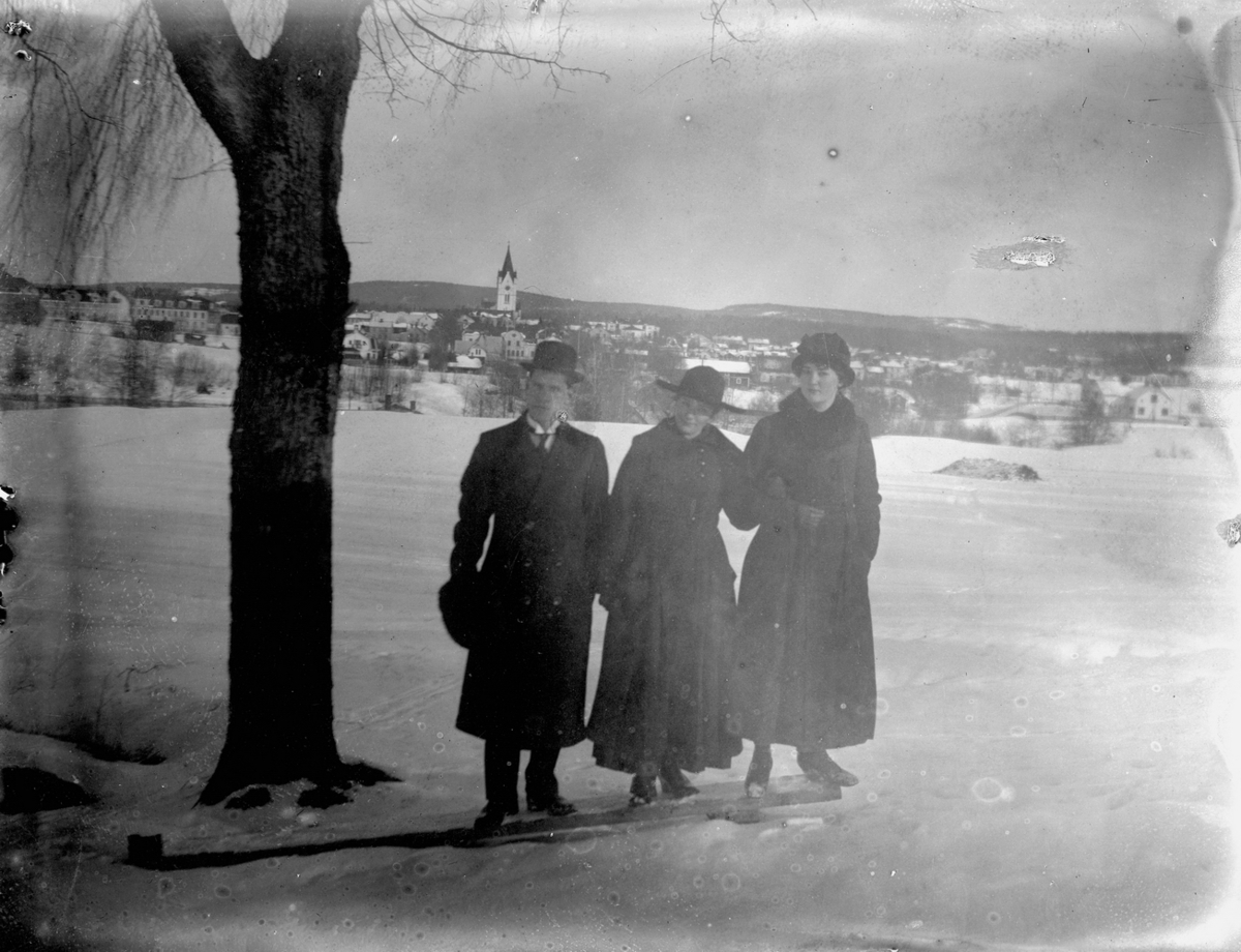 Karl Hedström och två kvinnor.
Nora med bl.a. kyrkan och bostadshus i bakgrunden.