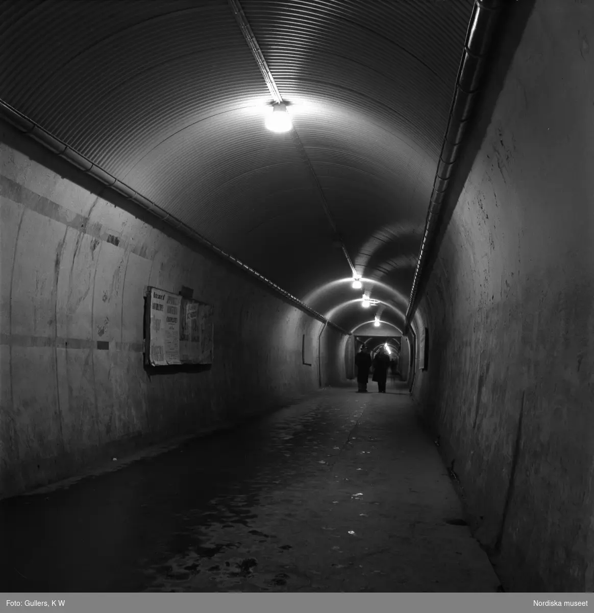Stockholm. "Brunkebergstunnelns långa, grå schakt ekar av stegen från de sista nattvandrarna."