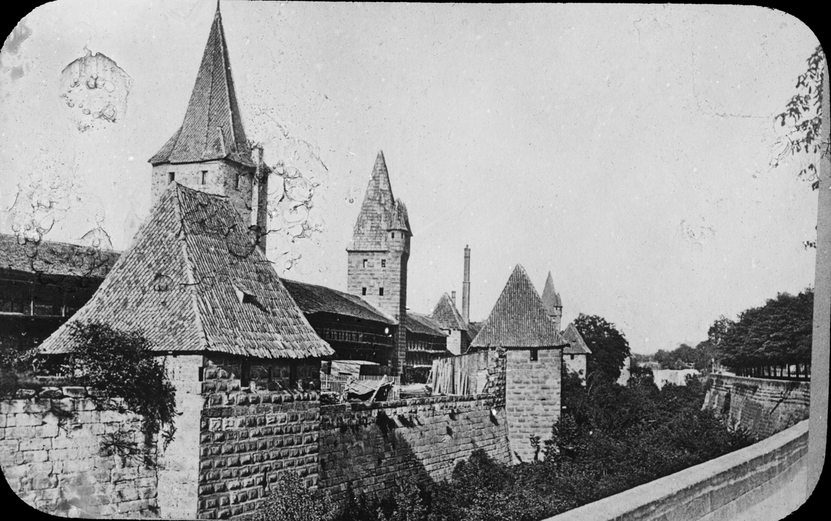 Skioptikonbild med motiv av mur vid Kaiserburg (Kejsarens Slott) Nürnberg.
Bilden har förvarats i kartong märkt: Nürnberg XII.  1901
