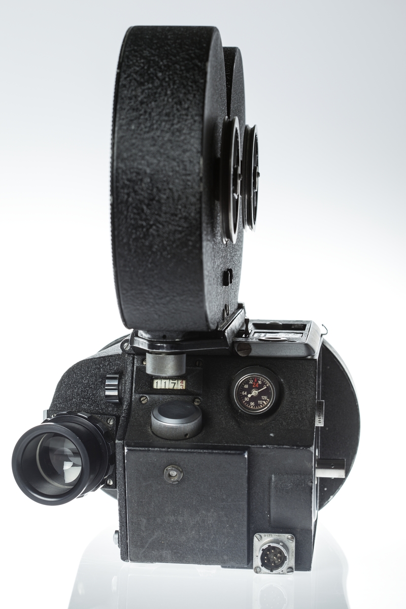 Filmkamera med magasin modell S4L nr 9567, 35 mm filmformat. Ett täcklock av metall som monteras istället för magasin medföljer.  Med Nikon 2x Telekonverter TC 201. Sladd för spänningsmatning. Passande höghastighetsmotor Mitchell modell 11D-2765 ser nr 100 i trälåda.
