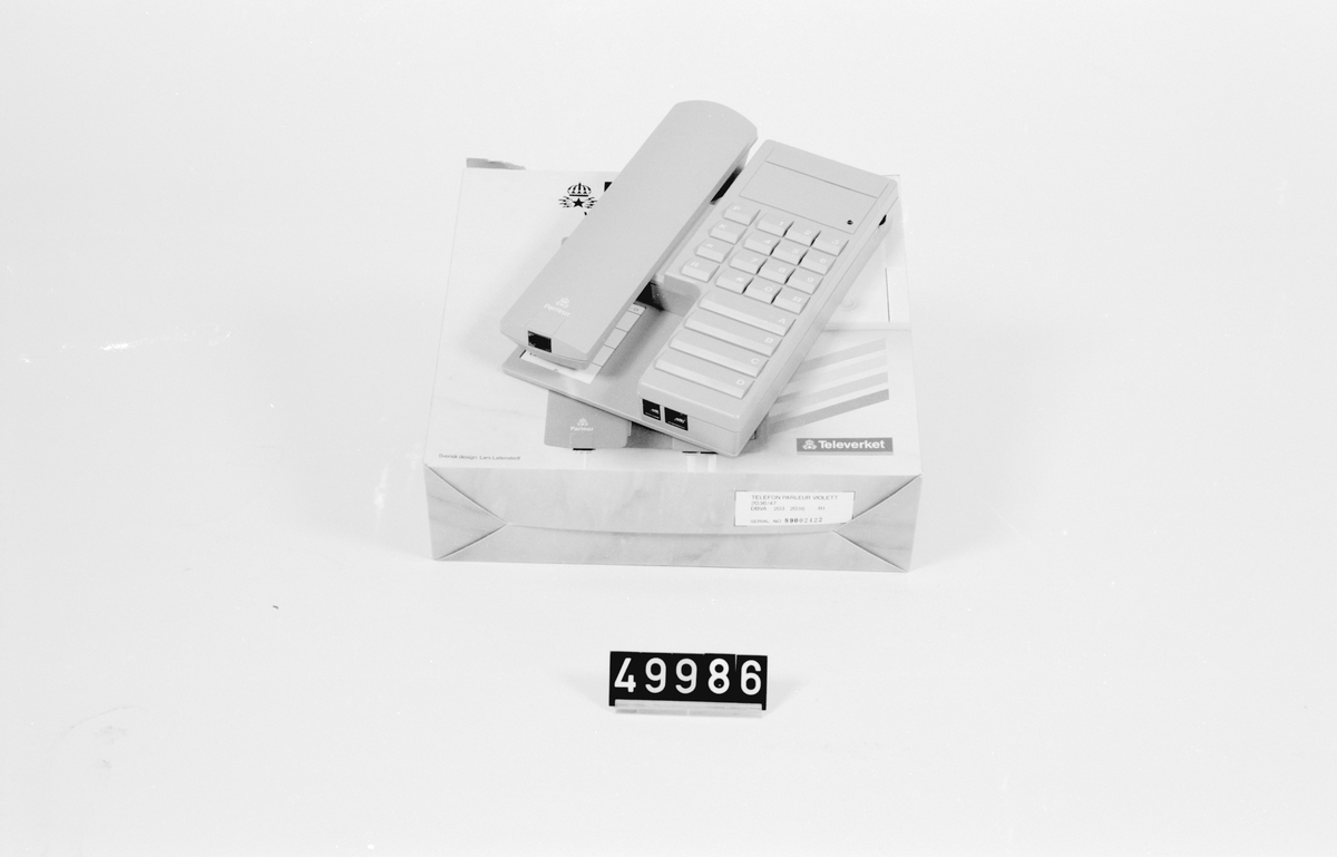 Lila telefonapparat i originalkartong, med bruksanvisning, fyra namnval, tio kortnr. repetition och tonval.