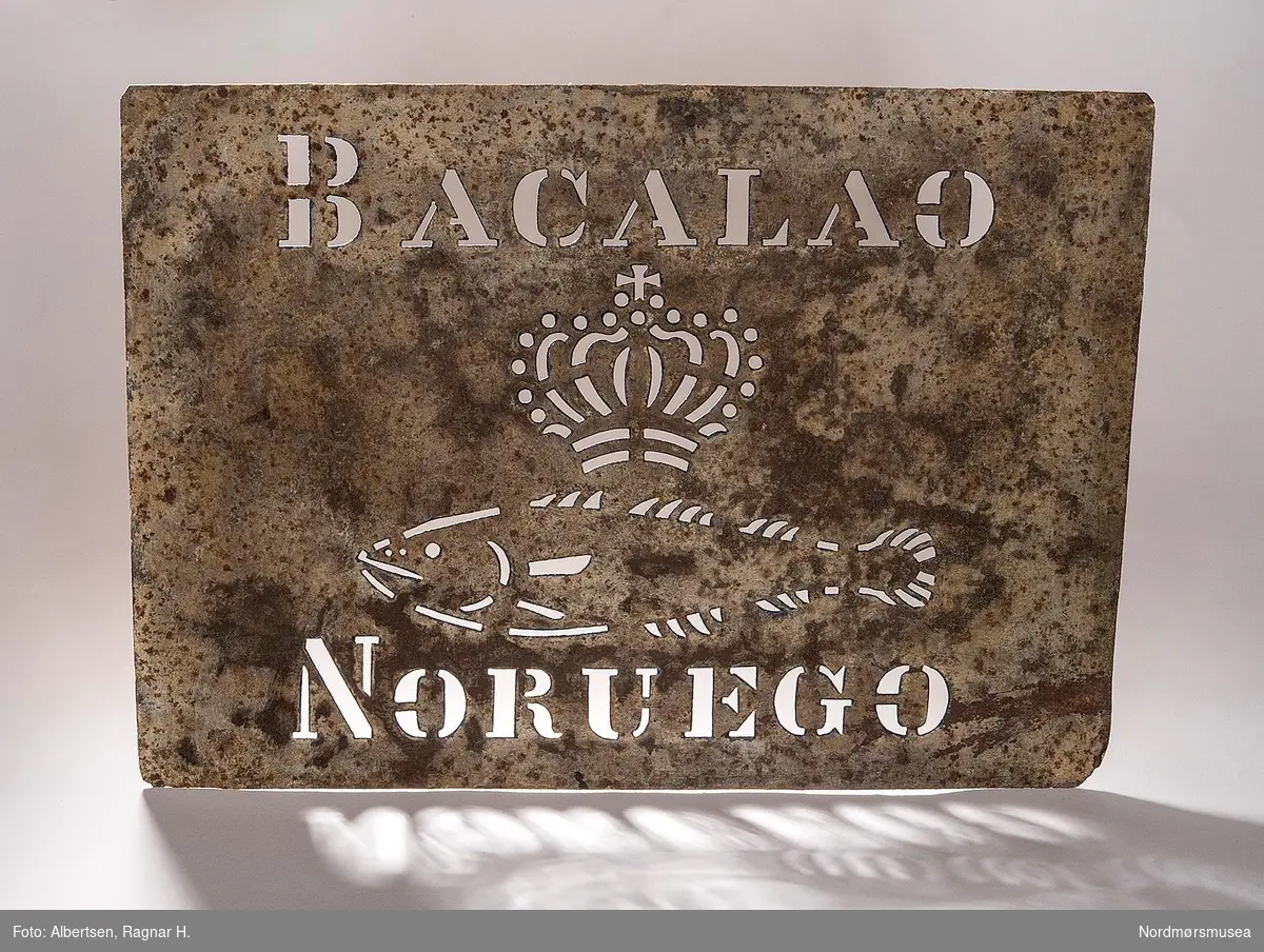 Rektangulær jernblikksjablon med tekst: "BACALAO NORVEGO", krone og fisk midt på sjablonen.