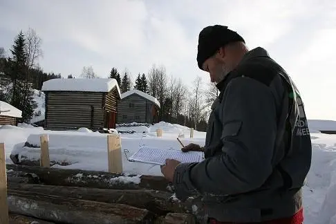 Mann noterer nummer på stokker og passer på at alle er registrert.