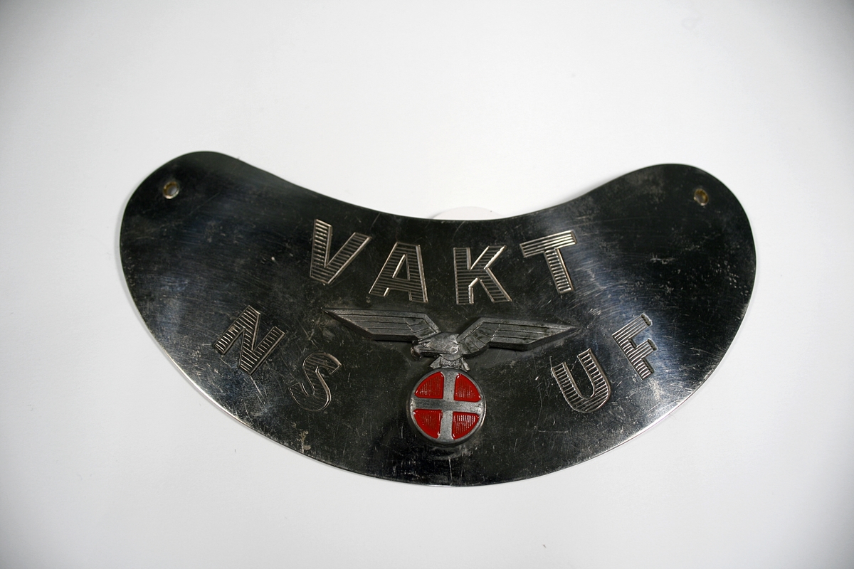 Metallskilt med Nasjonal samlings emblem, solkors med ørn. Skiltet kan henges rundt halsen ved hjelp av et kjede.