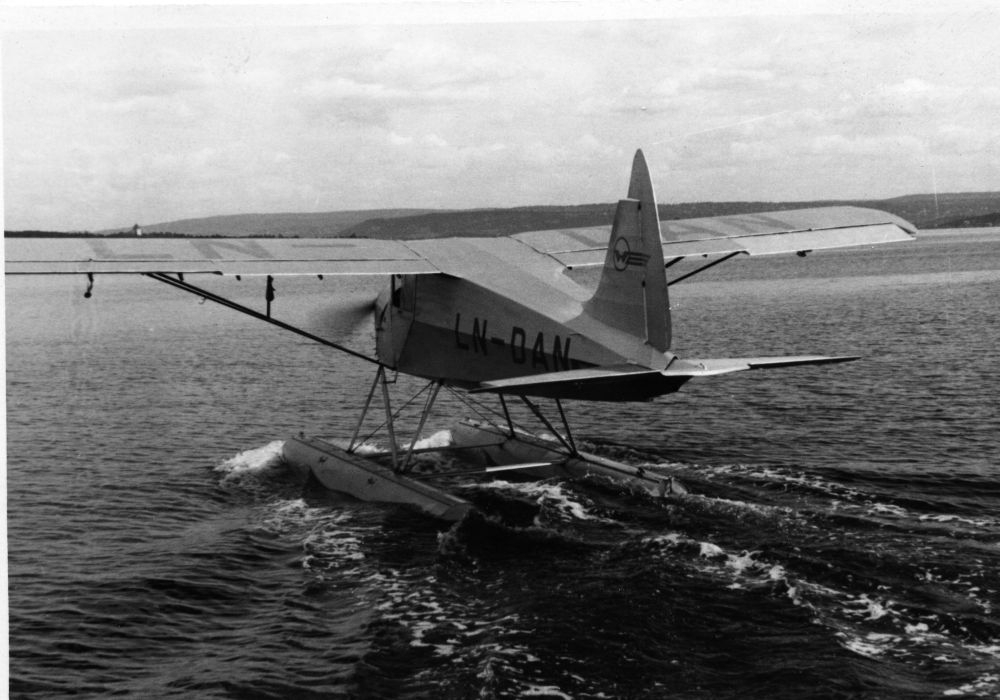 Landskap. Sjø. Et sjøfly, LN-DAN, type S.A.I. fra Widerøe taxer mot åpent hav for take off.