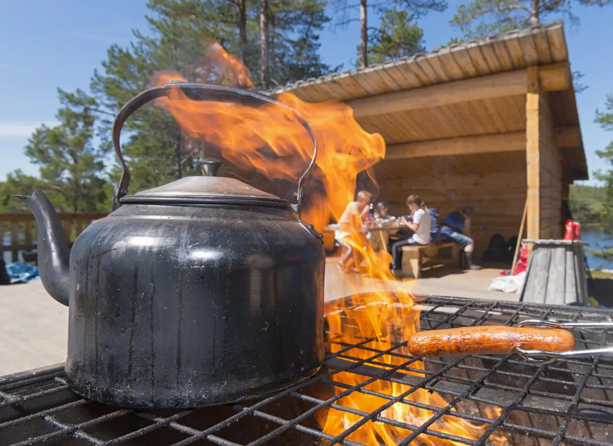 Pølsegrilling og kaffekoking på festplassen over bål.