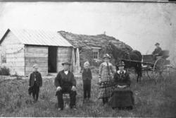 Hus,finklede,hatt,hest og kjerre.Emigrantar i Amerika.
Moti