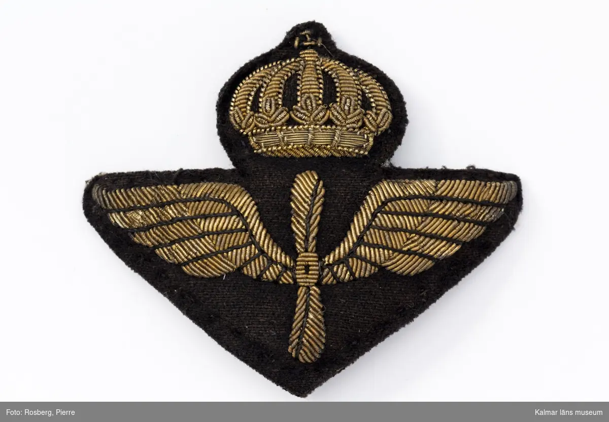 KLM 44531:19. Emblem, av textil och metall. Flygvapnets emblem för att fästa på uniformen. Av tyg och metalltråd, nål för fastsättning.
