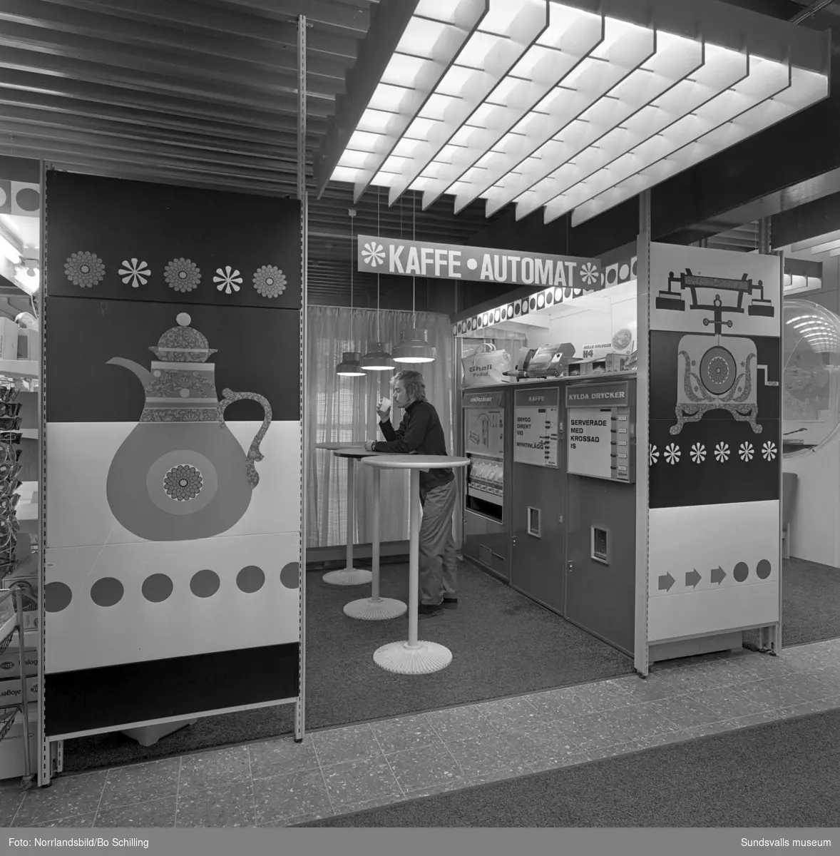 Shell bensinmack vid Rådhusgatan invid Skolhusallén, en modern mack med stort utbud av livsmedel, kläder och automater för varma och kalla drycker. Exteriör- och interiörbilder.