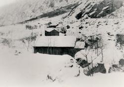 Eit gårdstun i Lilledalen dekket av snø.