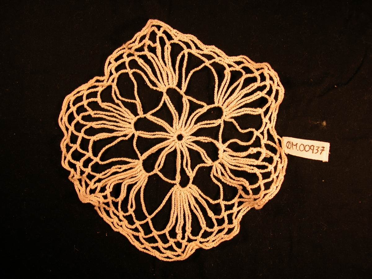 12 par stavar som er bundne saman med ein boge. På bogen er det festa 5 par stavar som dannar hand-liknande mønster. til saman er det 6 slike "hender". Kanten er tilnerma rutemønstra.