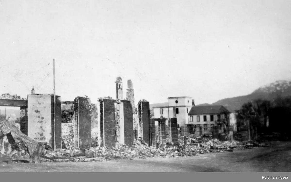Ruiner ved Langveien 1940 med Den høyere skole i bakgrunnen.  Til venstre rester av Gundersengården.  Kirklandets bedehus, Årsvold- og Fastinggårdene.  Kristiansund ble bombet i aprildagene 1940.
(Frå Nordmøre Museum si fotosamling)