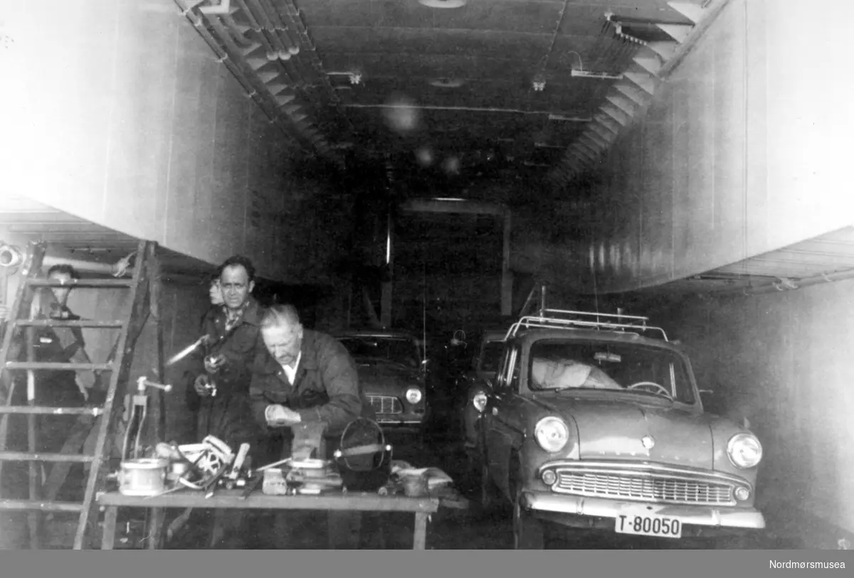 Bildet viser bildekket på fergen B/F"Gildeskål" bnr.18 ved Storviks Mek. Verksted. B/F"Gildeskål" ble levert til Salten Dampskipsselskap i 1963 og hadde følgende hoveddimensjoner L 46,00 m X B 9,40 m x D 4,10 m og hadde en tonnasje på 463 bruttoregistertonn og 2 dieselmotorer hver på 625 hk. Bilen med reg.nr. T 80050 er en Moskvitch (russisk bilmerke og kopi av førkrigs Opel Kadett). Mannen til venstre med skjærbrenneren er rørlegger Ole Helseth og den andre er platearbeider Kornelius Liabø.
 Mannen til venstre bak gardintrappa er vanskelig å kjenne igjen og likedan personen bak Ole Helseth. Bildet er fra 1963.
Kilde/tekst: Peter Storvik. Fra Nordmøre museums fotosamlinger.
