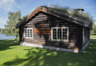 Barfrøstua er ei laftet tømmerstue med gress på taket, og den ligger flott til innunder noen høye graner, med utsikt til Mjøsa.