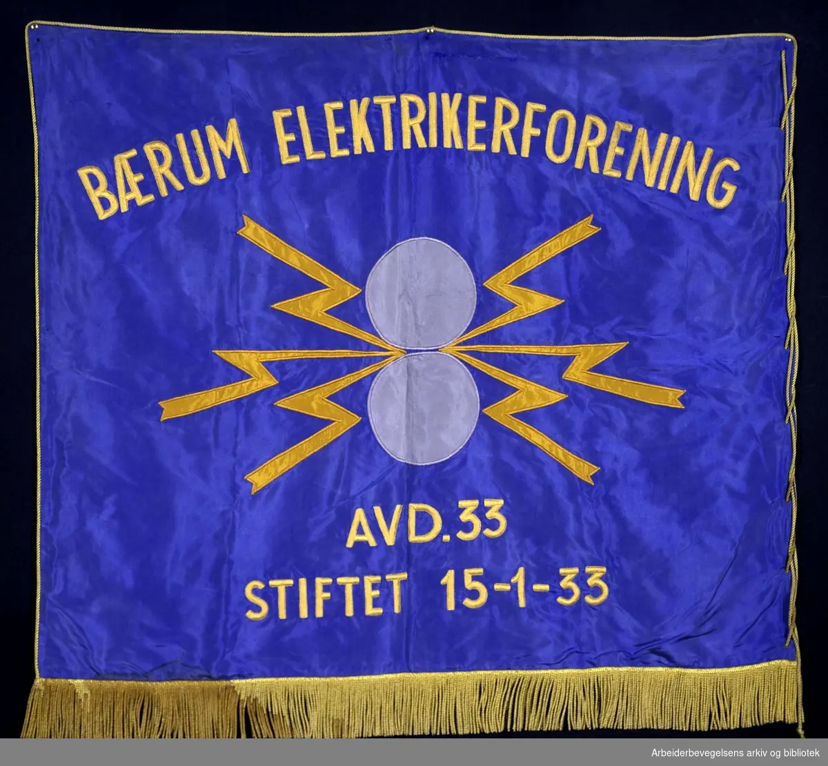 Bærum elektrikerforening avd 33.Stiftet 15. januar 1933..Forside..Fanetekst: Bærum Elektrikerforening avd. 33..Stiftet 15 - 1 - 33..Baksiden er lik
