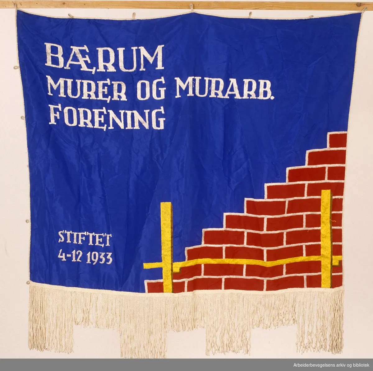 Bærum murer og murarbeiderforening.Stiftet 4. desember 1933..Forside..Fanetekst: Bærum murer og murarb. forening.Stiftet 4 - 12 1933
