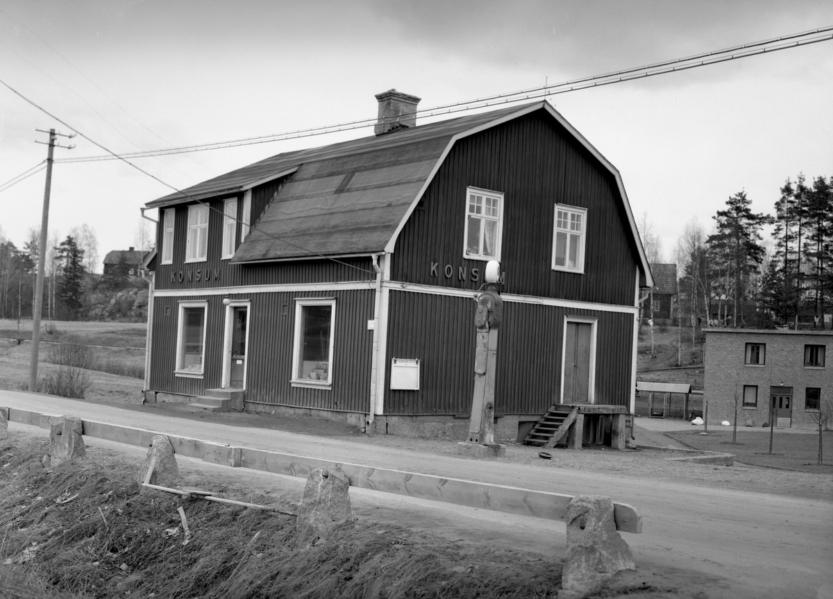 F.d. konsumbutiken i Jössefors nära fabriken. Byggnaden i bakgrunden till höger är tvättstugan hörande till fabriken. Bilden togs 8 april 1949.